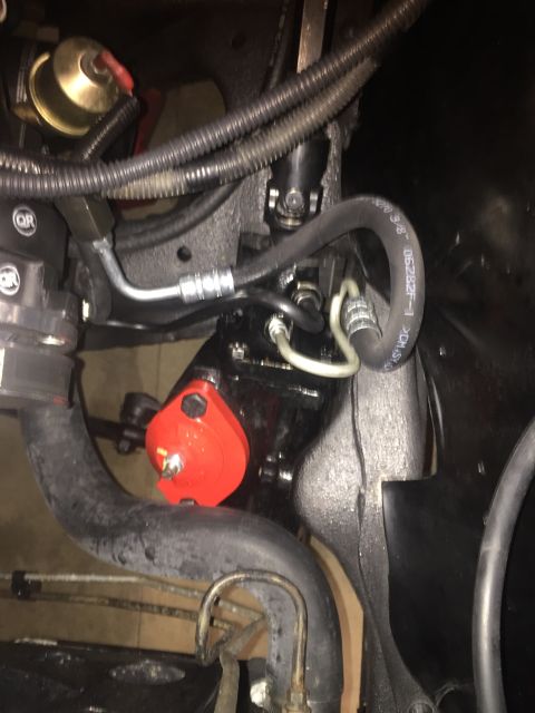 1982 Ford Bronco - Close-up view of a steering box with a red bracket and various hoses attached.