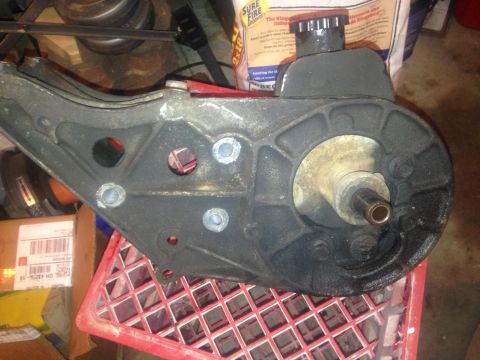 1993 Ford Bronco - Close-up of a black power steering pump assembly resting on a red plastic crate.