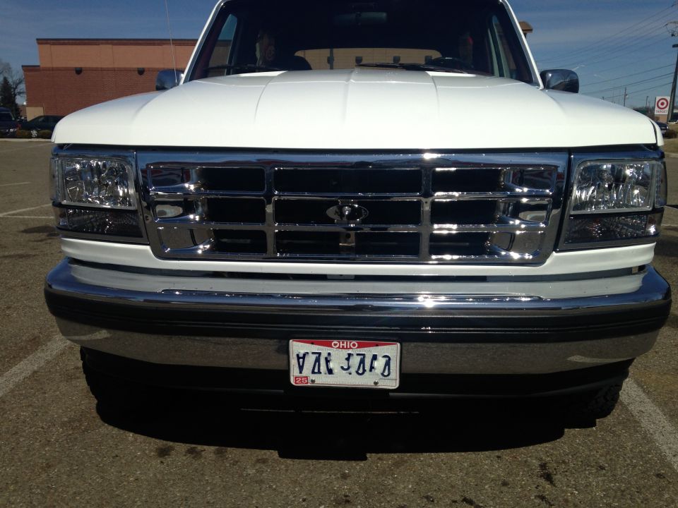 Front view of a white Ford Bronco with chrome grille and bumper, Ohio plate, parked in a lot