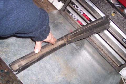 1990 Ford Bronco - A person is holding a worn slider gasket, likely a replacement part for a vehicle.