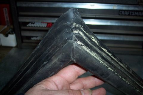 1990 Ford Bronco - Close-up of a worn rubber gasket corner, possibly for a vehicle component.