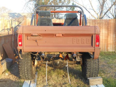 1972 Ford Bronco - Rear view of a brown 1978 Ford Bronco with a roll cage and large tires, parked outdoors.