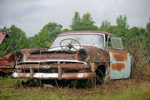 1972 Ford Bronco - This heavily rusted 1954 sedan sits abandoned in a field, its body showing significant decay.
