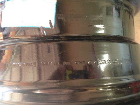 1987 Suzuki Samurai - Close-up of a black steel wheel showing manufacturing marks including '18x6.0JJ' and a date code.