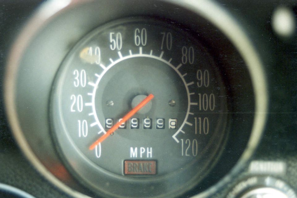 Speedometer gauge with needle pointing to 0, showing 999999 miles, and a BRAKE indicator light