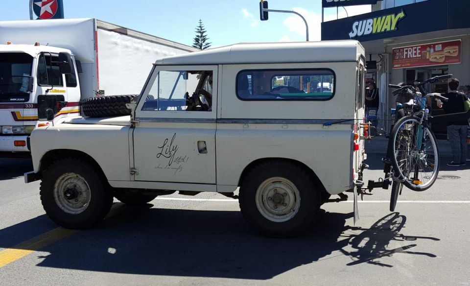 Cream Land Rover Defender with bicycle rack and bicycle on side