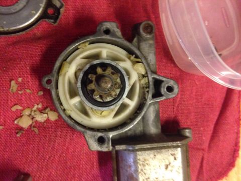 1993 Ford Bronco - The internal gears of a vehicle's window regulator motor are visible, showing wear and debris.