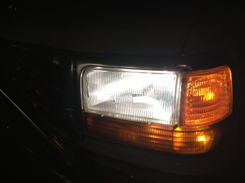 1995 Ford Bronco - Close-up of the headlight and amber turn signal assembly on a 1995 Ford Bronco.