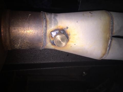 1982 Ford Bronco - Close-up of an exhaust pipe a welded bung and visible weld seams.