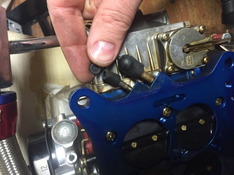 1982 Ford Bronco - Installing a rubber plug onto a carburetor assembly.