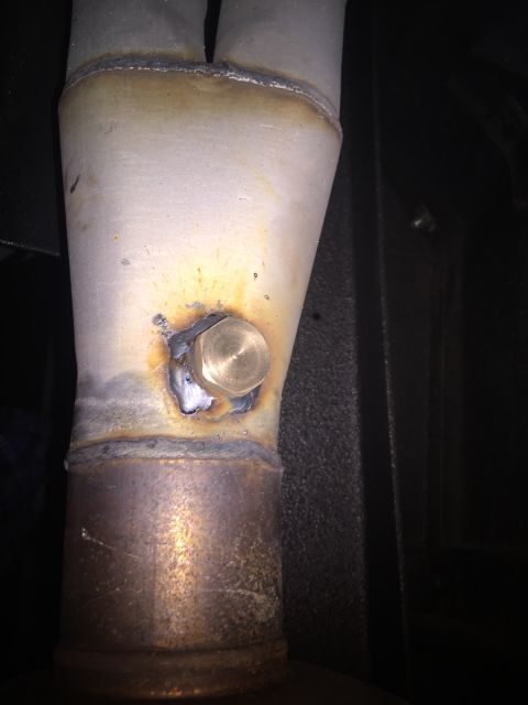 1982 Ford Bronco - Close-up of a welded exhaust pipe section with a brass bung, showing signs of modification.