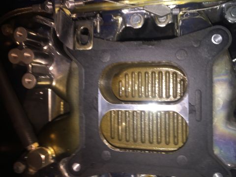 1982 Ford Bronco - Close-up of a carburetor base plate and gasket, showing intake ports.