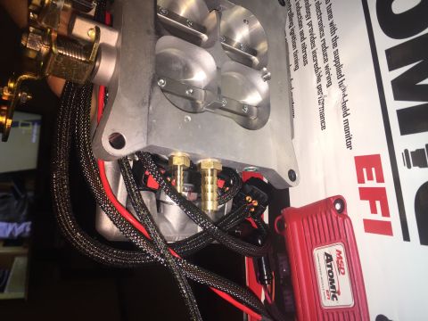 1982 Ford Bronco - A close-up view of a custom engine intake manifold with attached wiring and an MSD Atomic EFI power module. The components are mounted on a…