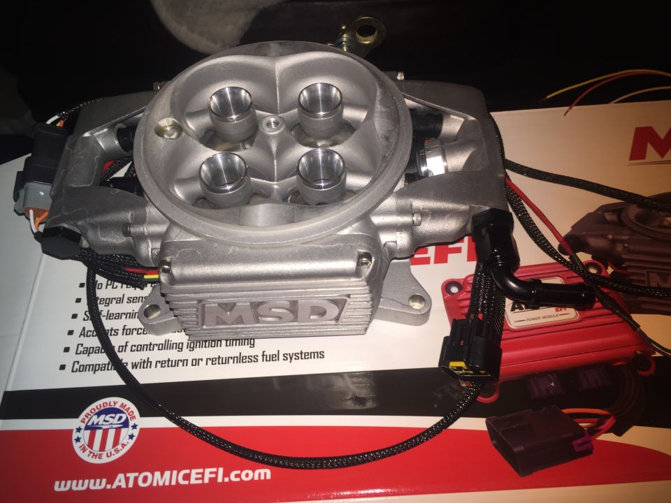 Silver MSD Atomic EFI throttle body on a box with text