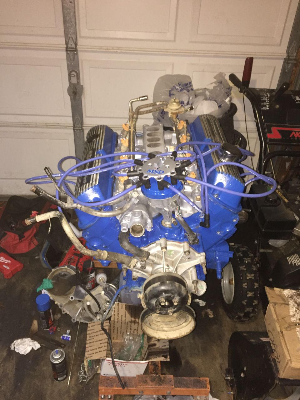 Blue V8 engine with MSD ignition components in a garage.