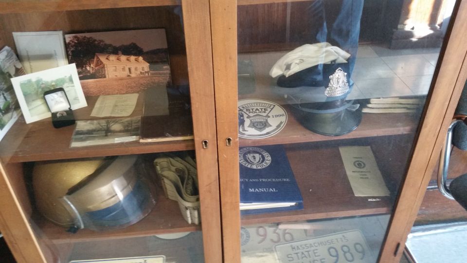 Wooden display cases with police hats, helmets, photos, manuals and plates