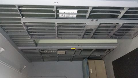 1991 Ford LTD Crown Victoria - Photo of a jail cell block hallway with chained barred doors, a storage bin and posted notice.
