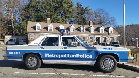 1991 Ford LTD Crown Victoria - Photo of a Metropolitan Police Ford Crown Victoria cruiser, side profile outside a stone station.