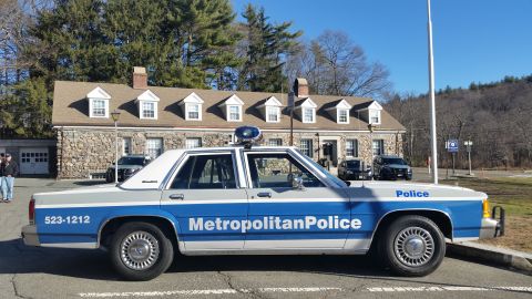1991 Ford LTD Crown Victoria - Photo of a Metropolitan Police Ford Crown Victoria cruiser parked at a stone police station.
