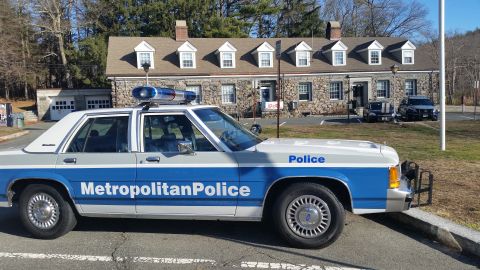 1991 Ford LTD Crown Victoria - Photo of a Metropolitan Police Ford Crown Victoria cruiser with a push bar outside a stone station.