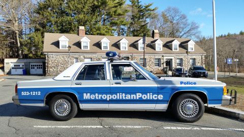 1991 Ford LTD Crown Victoria - Photo of a blue and white Metropolitan Police Ford Crown Victoria cruiser, side view at a stone station.