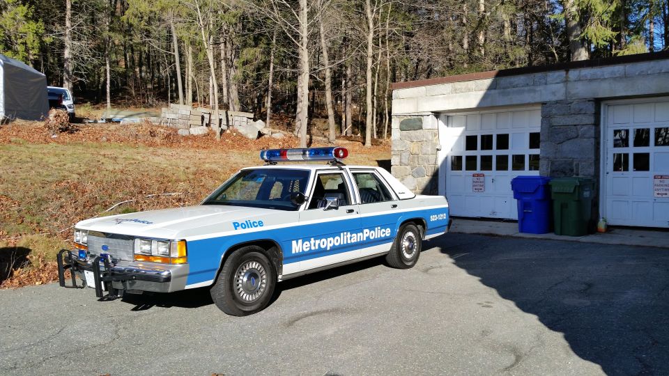 Metropolitan Police Ford sedan parked beside garage doors
