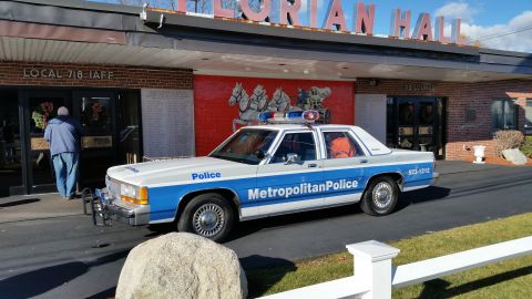 1991 Ford LTD Crown Victoria - Photo of a vintage Ford Metropolitan Police patrol car at the Florian Hall entrance, not a technical document.
