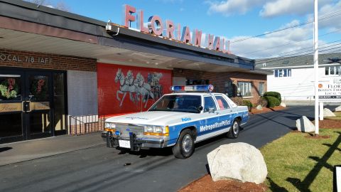 1991 Ford LTD Crown Victoria - Photo of a vintage Ford Metropolitan Police patrol car on a driveway at Florian Hall, not a technical document.