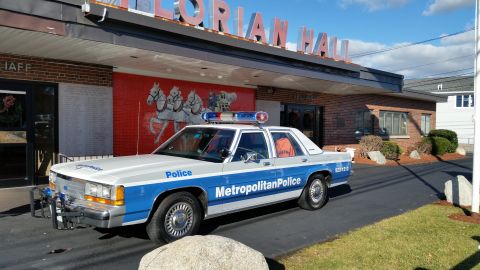 1991 Ford LTD Crown Victoria - Photo of a vintage Ford Metropolitan Police patrol car parked outside Florian Hall, not a technical document.