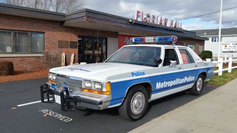 1991 Ford LTD Crown Victoria - Photo of a vintage Ford Metropolitan Police patrol car parked at Florian Hall, not a technical document.