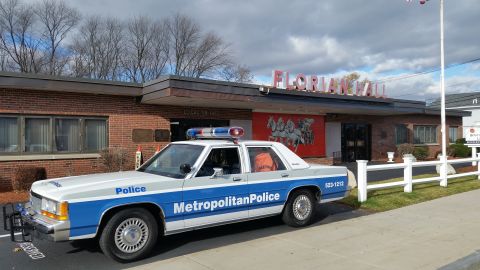 1991 Ford LTD Crown Victoria - Photo of a blue-and-white Metropolitan Police Crown Victoria parked outside a building, not a technical document.