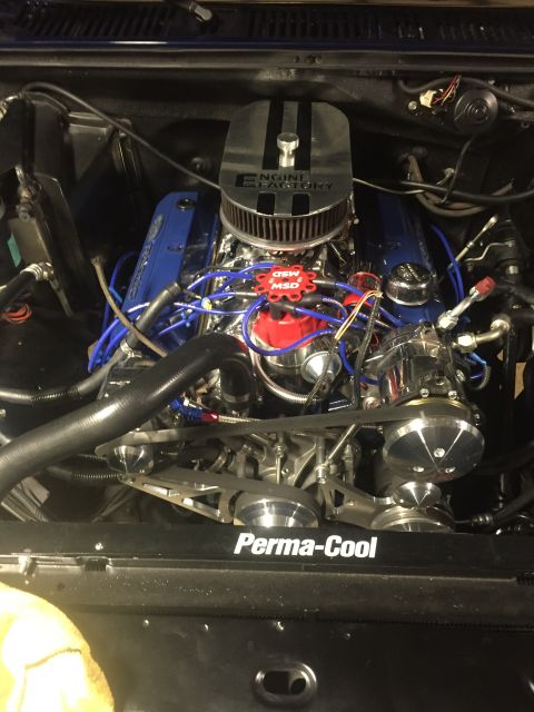 1982 Ford Bronco - A detailed, close-up view of a highly modified V8 engine bay, featuring a chrome air cleaner with "ENGINE FACTORY" branding and bright blue…