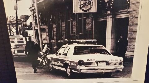 1991 Ford LTD Crown Victoria - A 1991 Ford Crown Victoria police car is parked outside a police station with officers present.