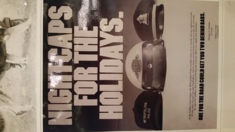 1991 Ford LTD Crown Victoria - Metropolitan Police anti-drunk-driving public-service poster headlined Nightcaps for the Holidays with police caps.