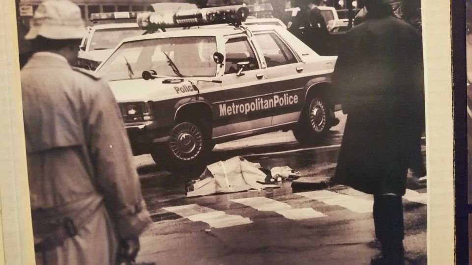 Vintage photo of officers and a Metropolitan Police station wagon at a rainy street scene