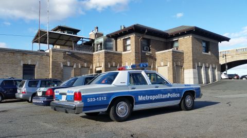 1991 Ford LTD Crown Victoria - Photograph of a Metropolitan Police Ford Crown Victoria patrol car in a parking lot, not a technical document.