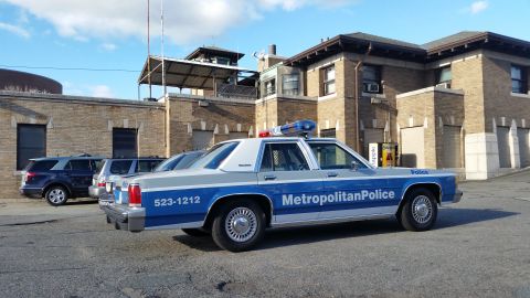 1991 Ford LTD Crown Victoria - Photograph of a Metropolitan Police Ford Crown Victoria patrol car parked at a lot, not a technical document.