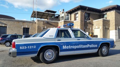 1991 Ford LTD Crown Victoria - Photograph of a Metropolitan Police Ford Crown Victoria patrol car parked at a station, not a technical document.
