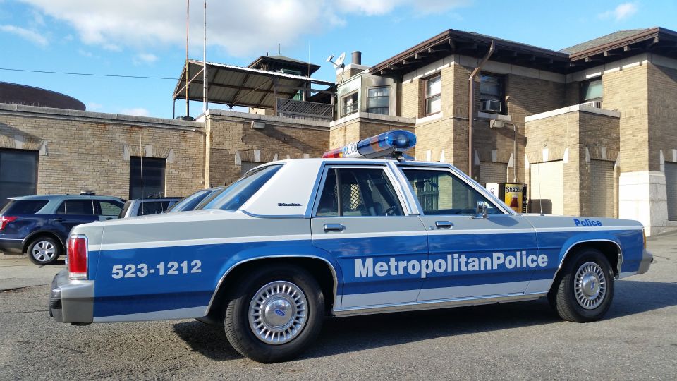 Side view of a blue and silver Metropolitan Police Ford Crown Victoria patrol car