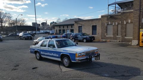 1991 Ford LTD Crown Victoria - Photograph of a Metropolitan Police Ford Crown Victoria patrol car at a station lot, not a technical document.