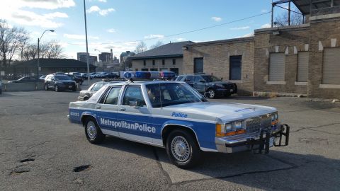 1991 Ford LTD Crown Victoria - Photograph of a Metropolitan Police Ford Crown Victoria patrol car in a station lot, not a technical document.