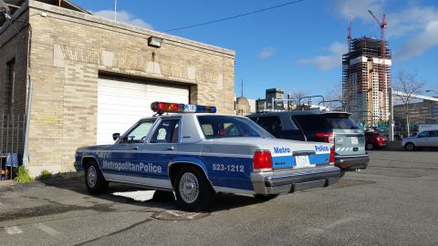 1991 Ford LTD Crown Victoria - Photograph of a Metropolitan Police Ford Crown Victoria patrol car in a city lot, not a technical document.