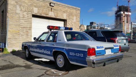 1991 Ford LTD Crown Victoria - Photograph of a Metropolitan Police Ford Crown Victoria patrol car parked in an urban lot, not a technical document.