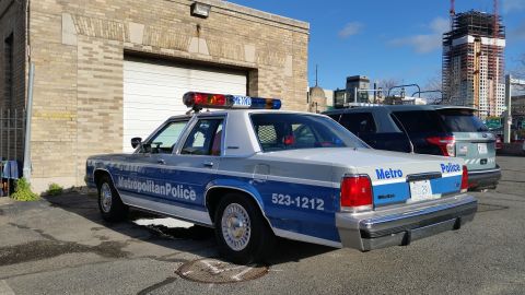1991 Ford LTD Crown Victoria - Photograph of a Metropolitan Police Ford Crown Victoria patrol car parked in an urban lot, not a technical document.