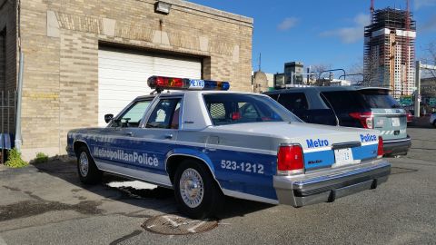 1991 Ford LTD Crown Victoria - Photograph of a Metropolitan Police Ford Crown Victoria patrol car in an urban lot, not a technical document.