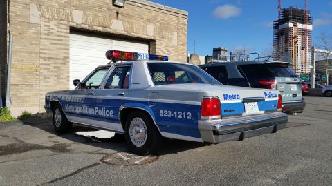 1991 Ford LTD Crown Victoria - Photograph of a Metropolitan Police Ford Crown Victoria patrol car in an urban lot, not a technical document.