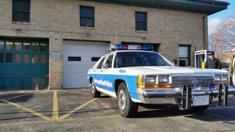 1991 Ford LTD Crown Victoria - Photo of a Metropolitan Police Ford Crown Victoria sedan parked outside a brick building.
