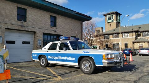 1991 Ford LTD Crown Victoria - Photo of a Metropolitan Police Ford Crown Victoria patrol car parked outside a brick building.