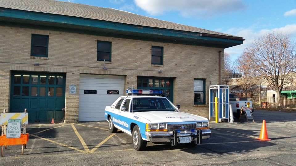 White car parked outside a brick building