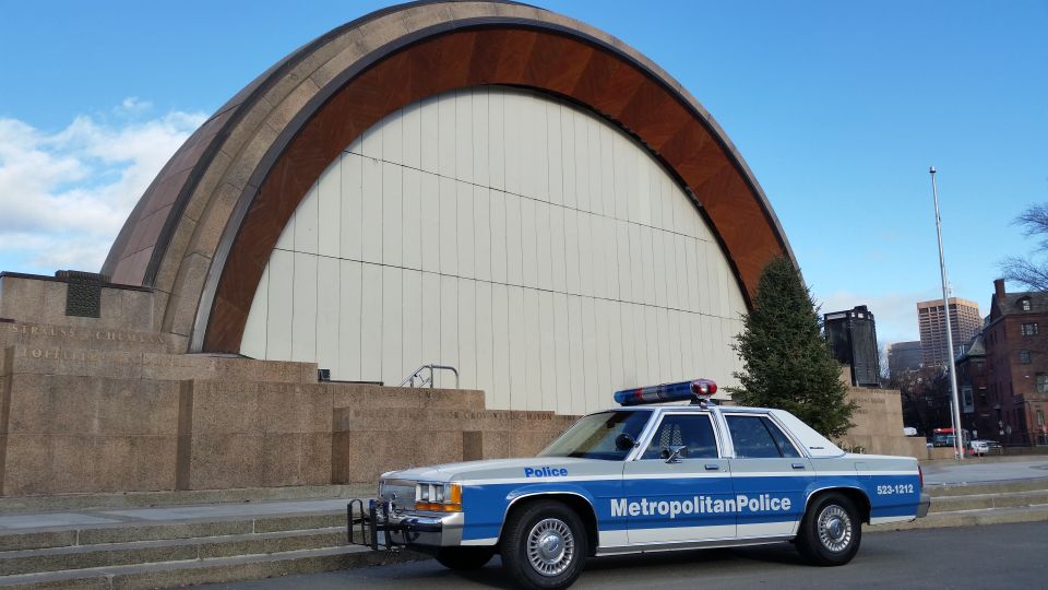 Police car with 'Metropolitan Police' on the side parked in front of a building with a large arched roof